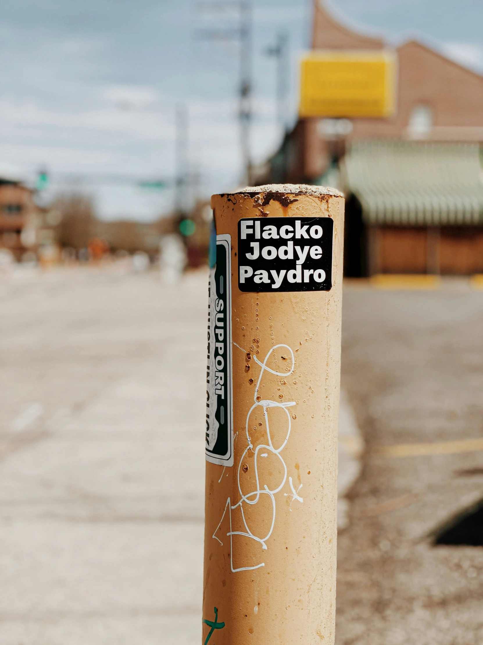 a pole is on the side of the road covered in graffiti