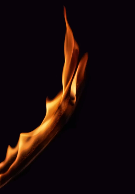 orange, blurred flame is seen on the surface of a dark background