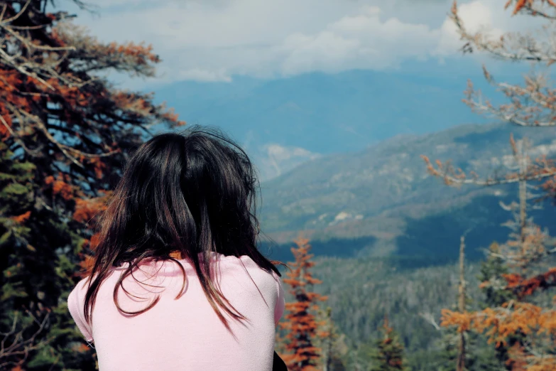 the back of a girl looking at mountains