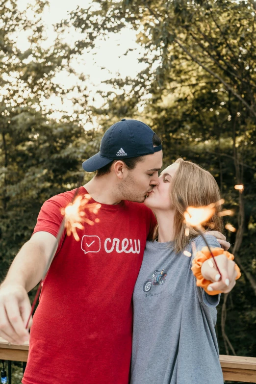 a couple kiss while standing by a fire