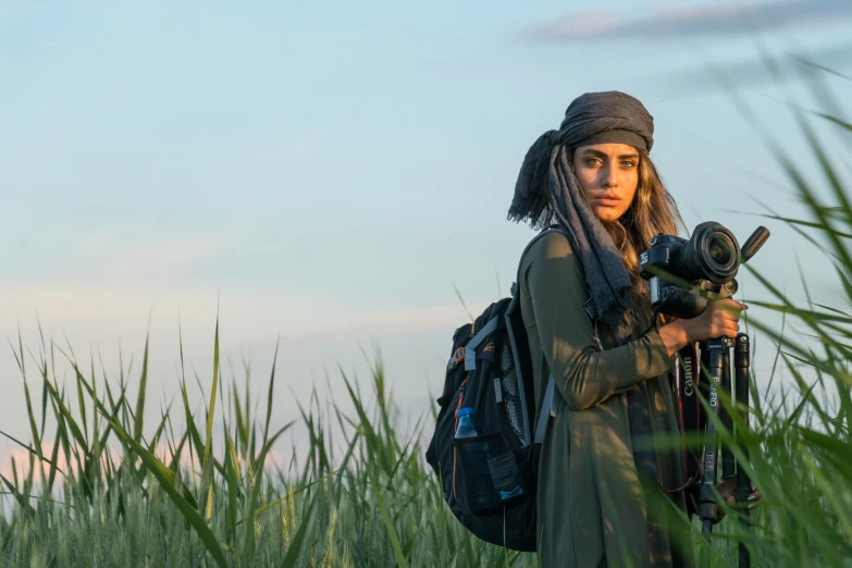 a woman with dreadlocks standing in tall grass