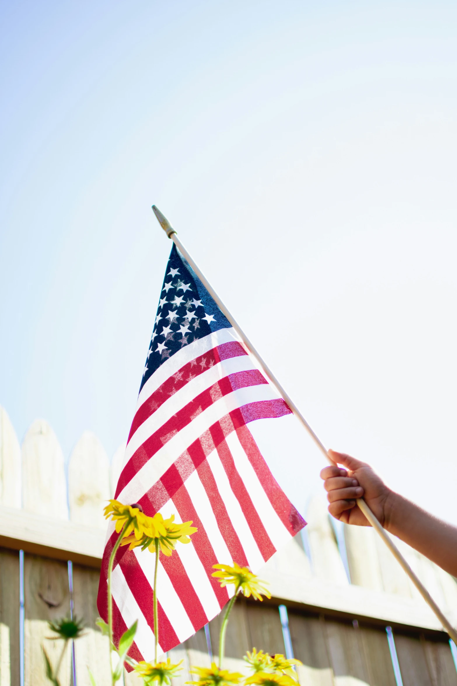an american flag on a stick with daisies