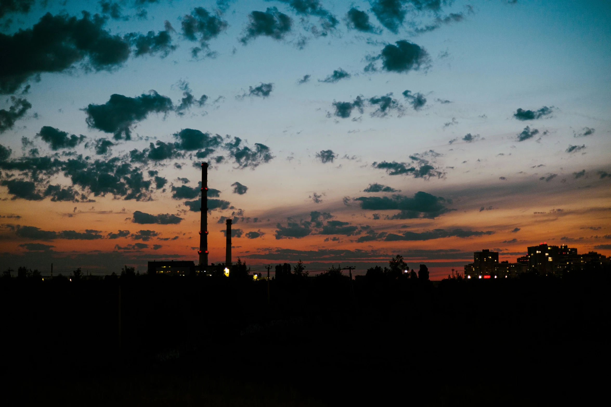 a city skyline with dark clouds and blue sky