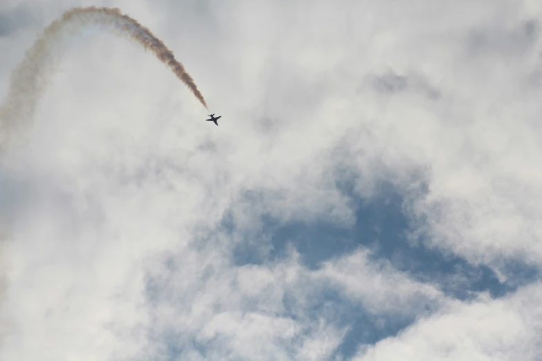 an airplane is flying in the cloudy sky