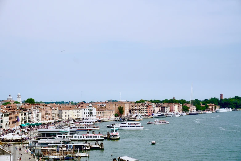 a river filled with lots of boats next to a large city