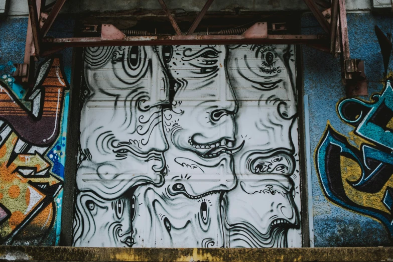 a bunch of graffiti on a building near some doors