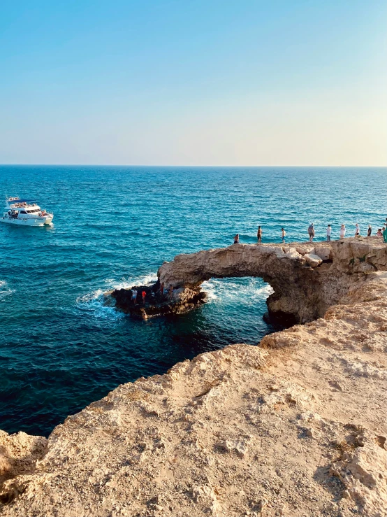 many people are standing at the edge of the ocean watching soing