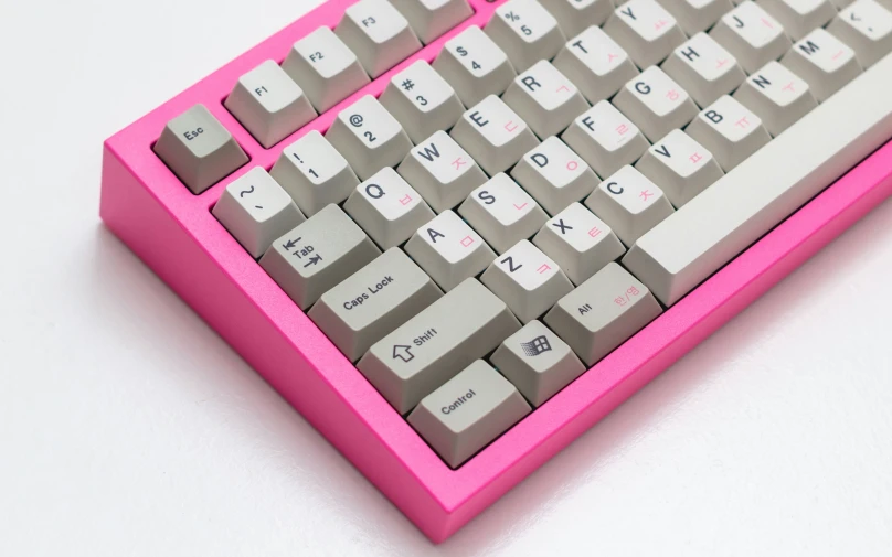 pink computer keyboard sitting on a white surface