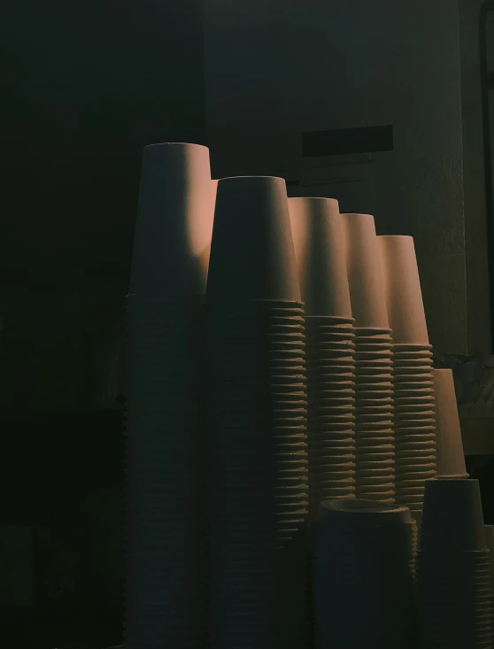 a bunch of big white cups sit on a table
