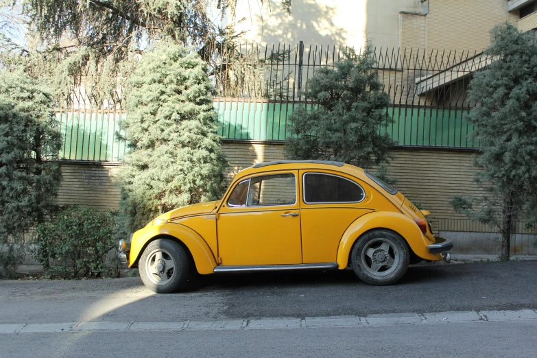 a yellow beetle is parked in front of a building