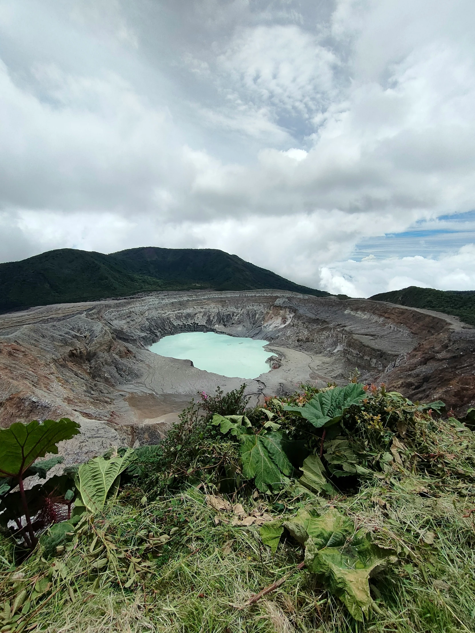 a blue water lake sitting on top of a dirt hill