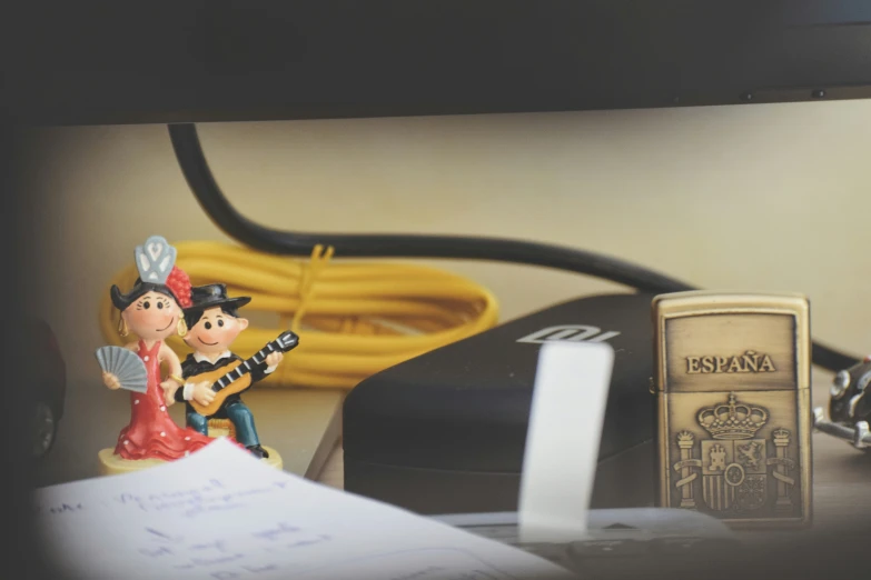 a small figurine sitting next to some writing and books