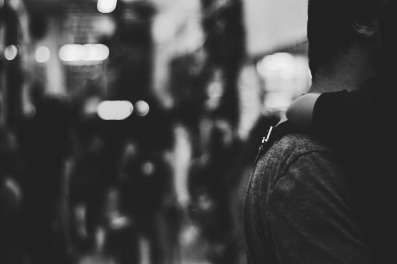 the silhouettes of two people hugging in a dark, crowded city