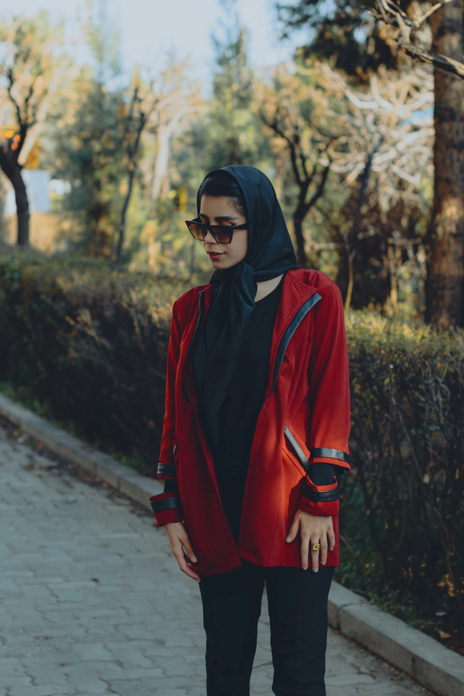 a woman is wearing sunglasses, and she is wearing a red jacket