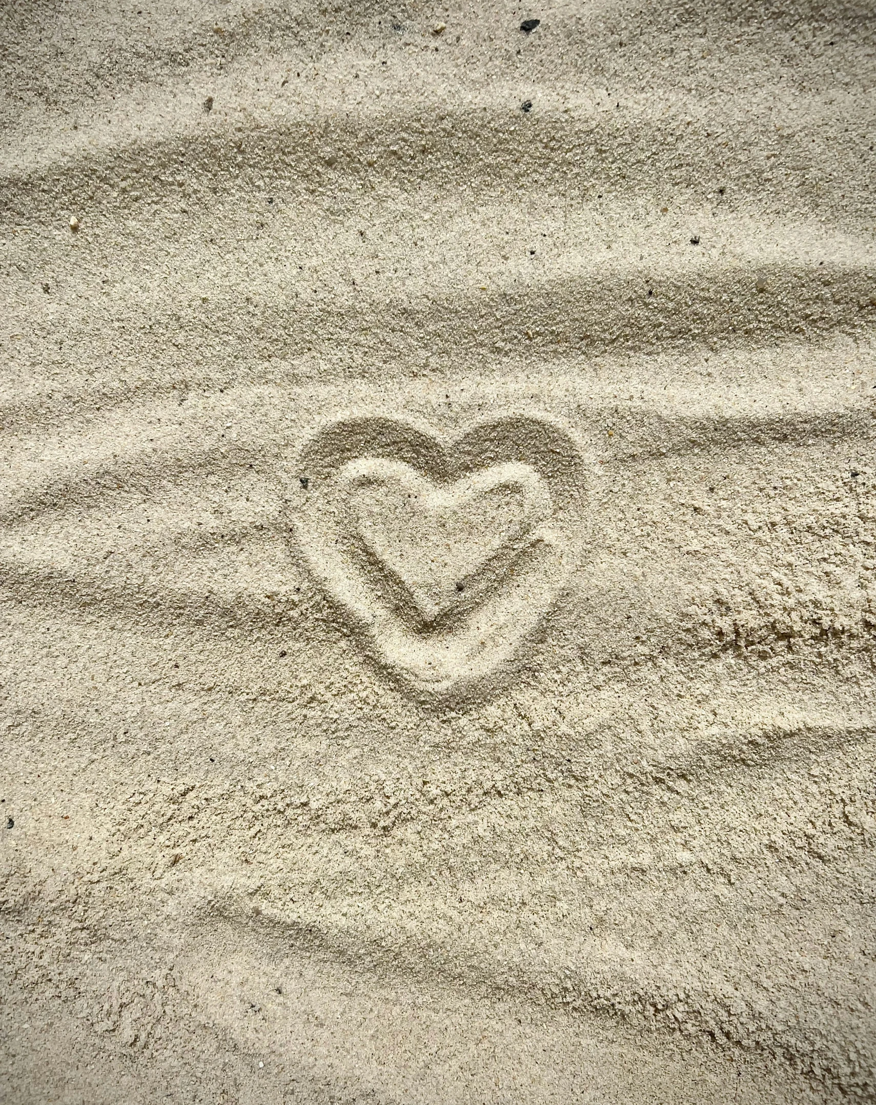 heart drawn on the sand in the sand