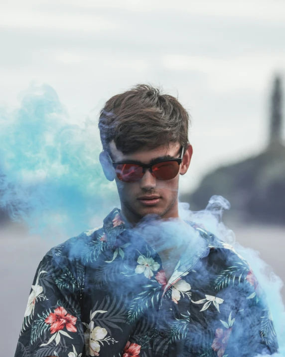 a man standing next to a street wearing shades