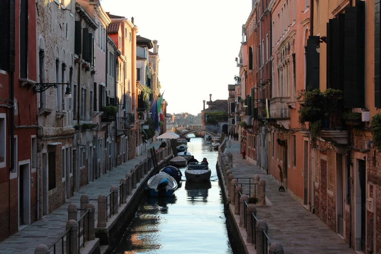 narrow canal surrounded by brick buildings in the evening