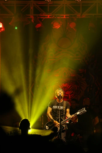 a man standing on stage while playing a guitar