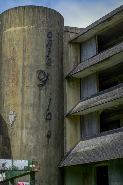 a rusty old grain silo near an abandoned building