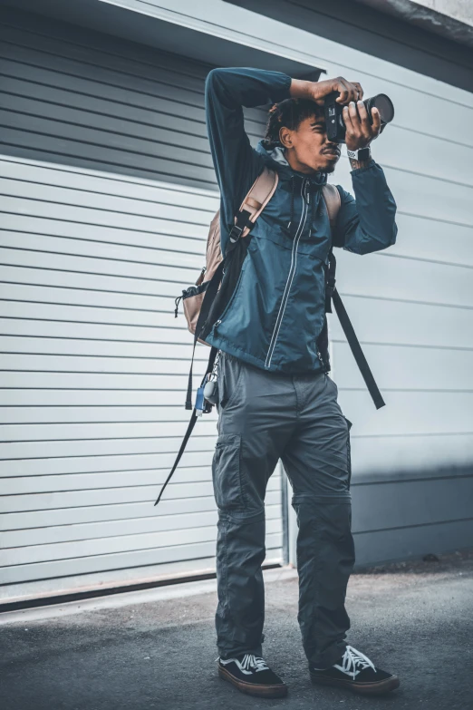 a man stands in front of a garage and takes a po