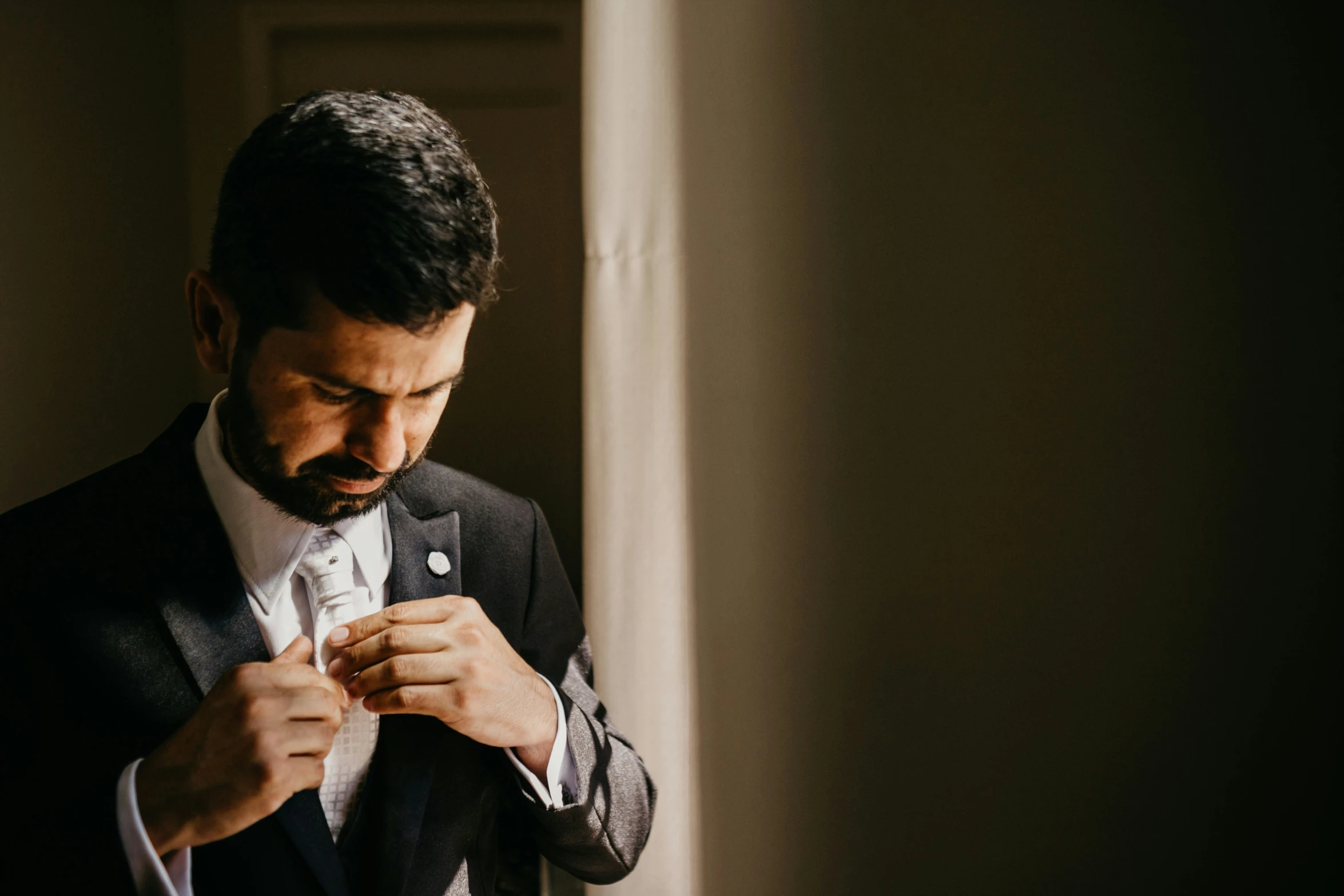 a man is helping his friend put on his tie