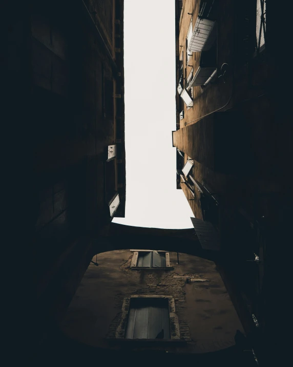 a narrow street lined with tall buildings under a cloudy sky