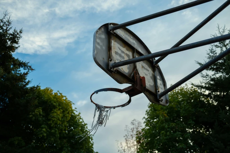 the back of a basketball hoop in flight in front of trees