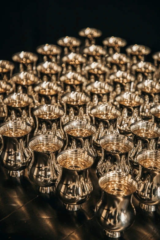 many silver cup holders stacked together and arranged in rows