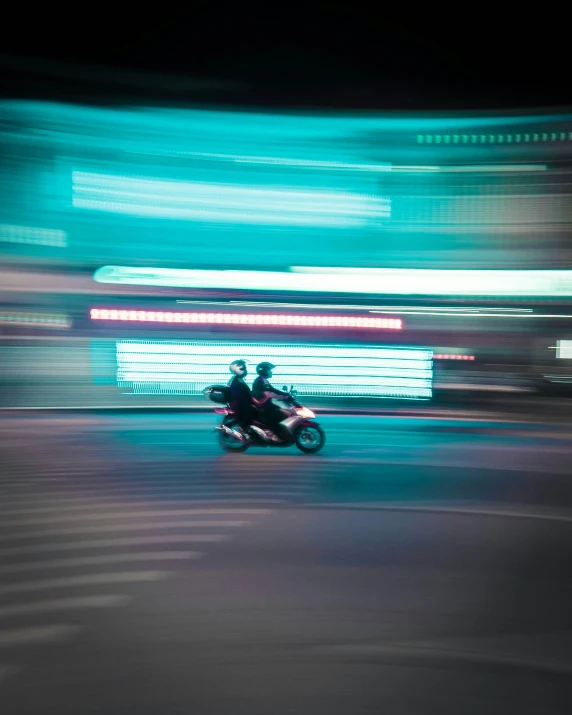 a motorcycle driver riding in the street during the night