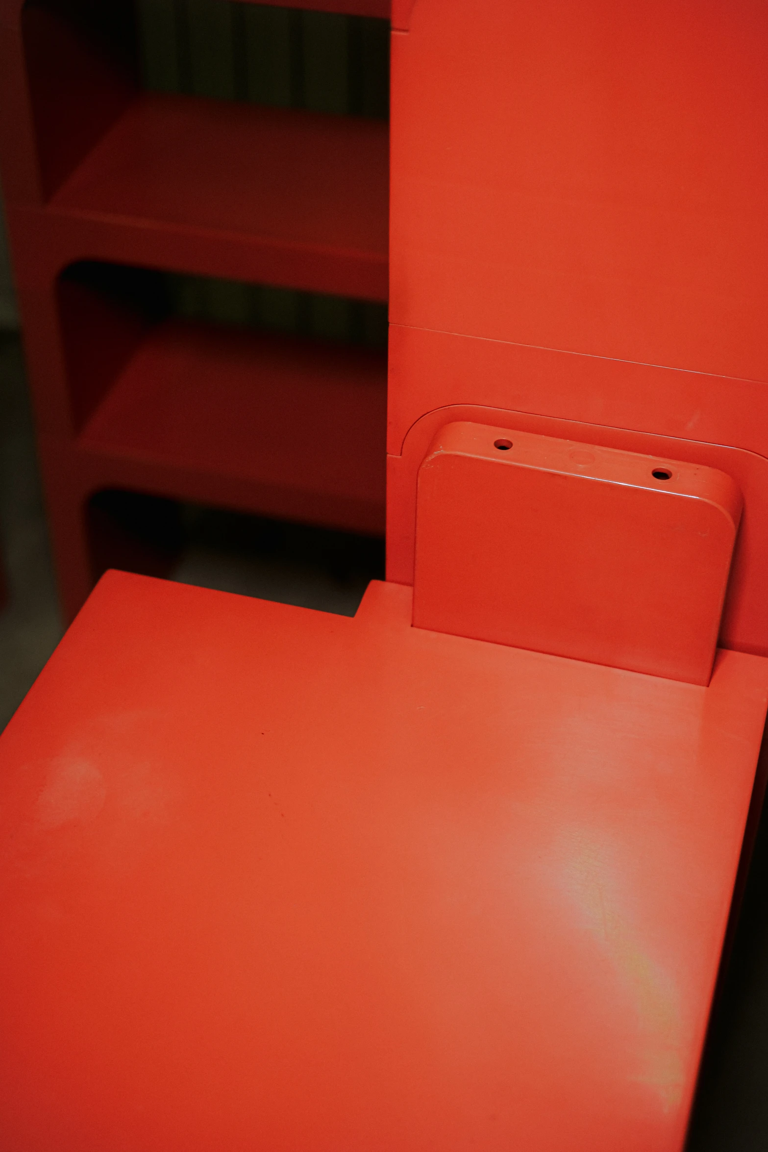 a red leather chair and foot rest on a carpet