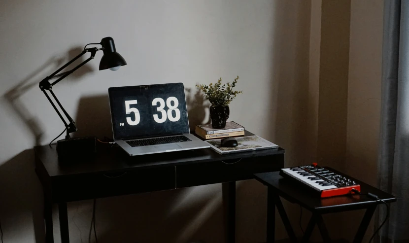 a table with a clock and computer monitor on it