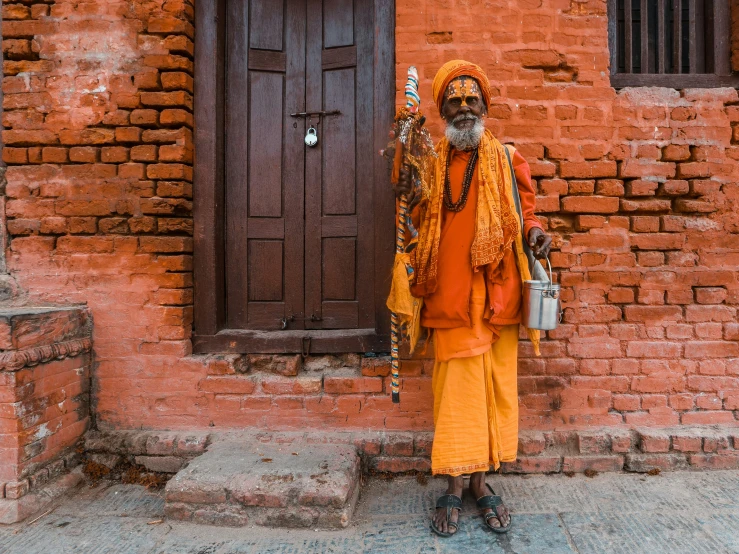 an elderly man holding a bucket and standing outside