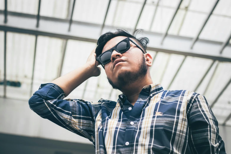 a man holding his glasses to the ceiling