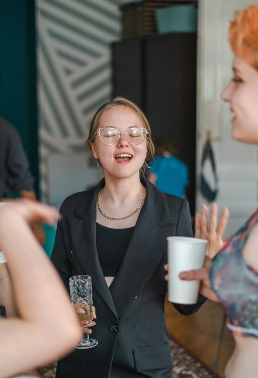 a woman wearing glasses has drinks and laughs