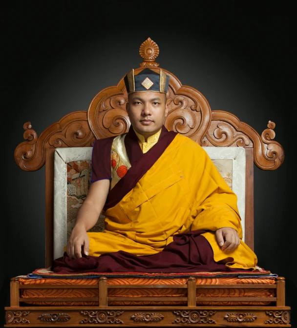 a man wearing a thai crown sitting on a bench