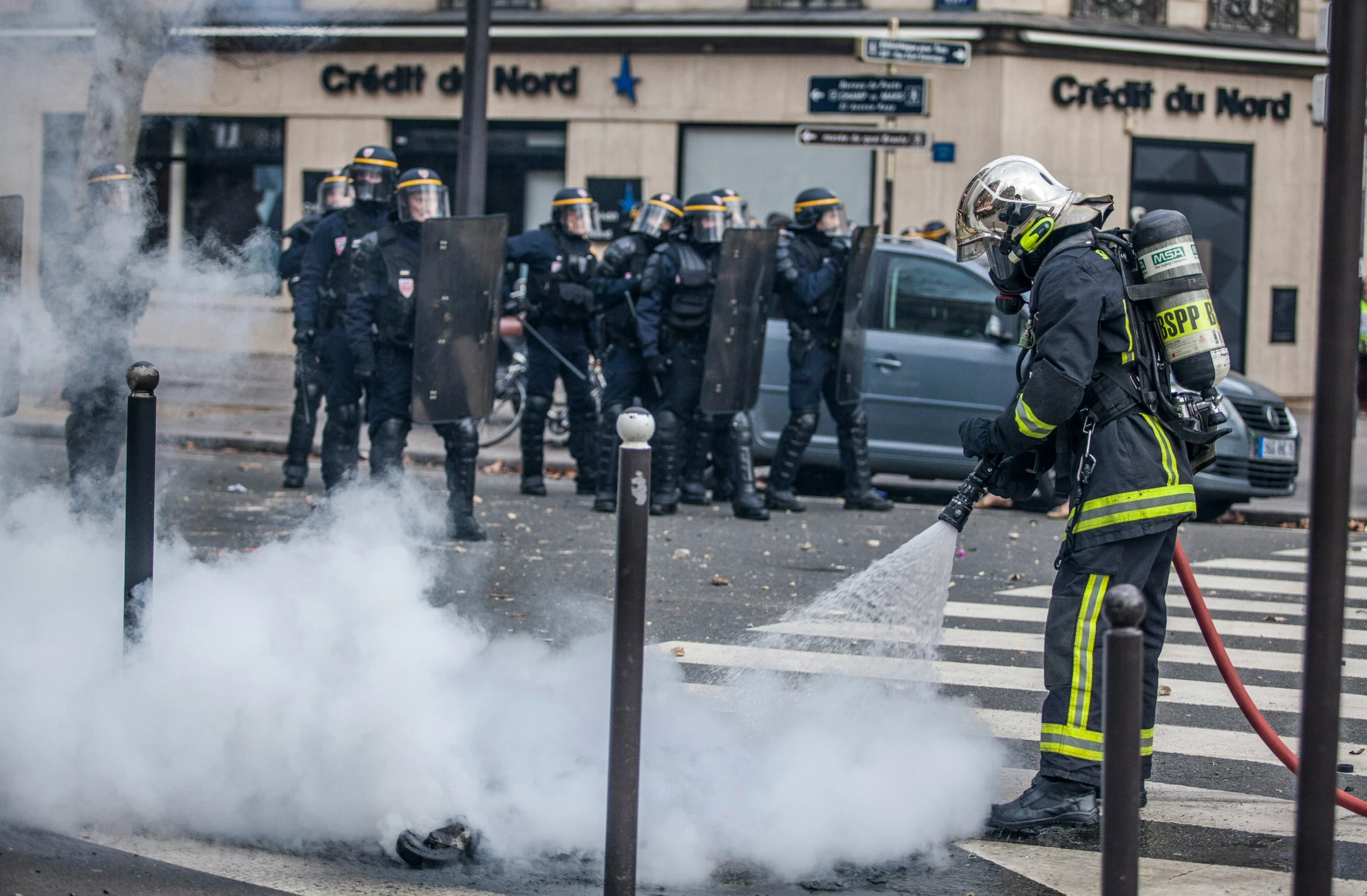 a fireman extinguish a car that has been shut down