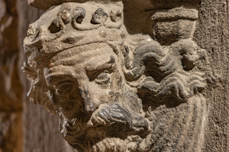a close up of a gargoyle on the outside wall of a building