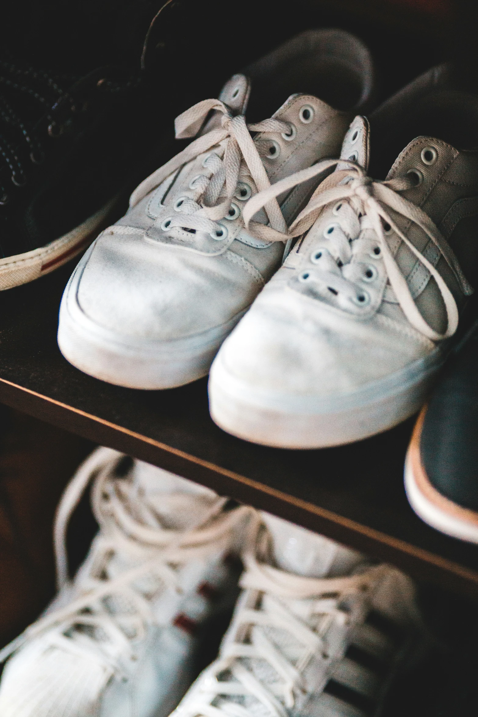 a couple of white sneakers and one black and gray shoe