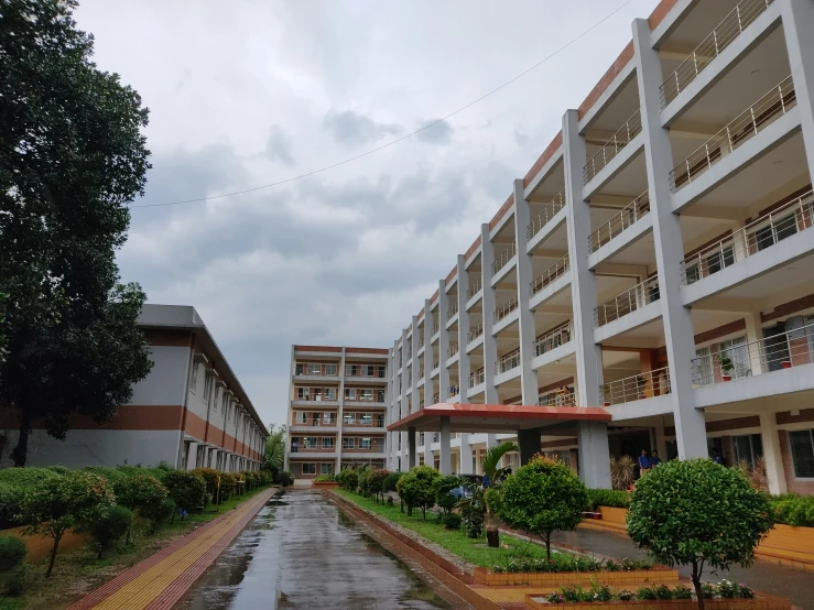a row of four buildings in the rain, with one building partially empty