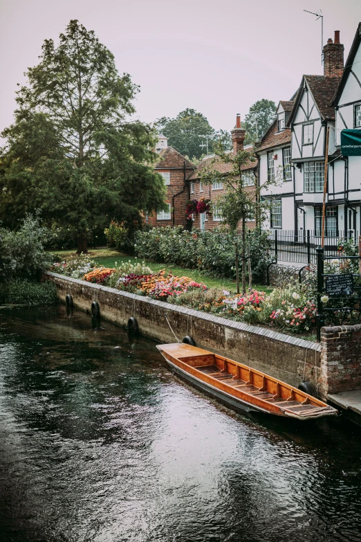 a small boat moving down a river with people walking