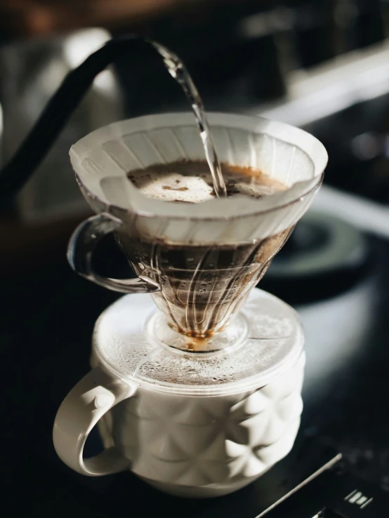 a pour over a stove top with liquid coming out of it