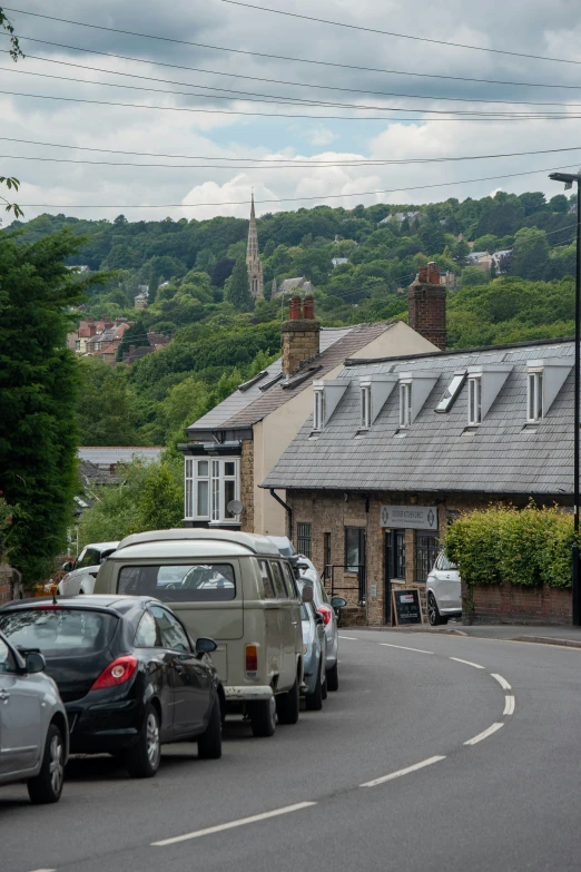 cars parked on the side of the road in front of a house