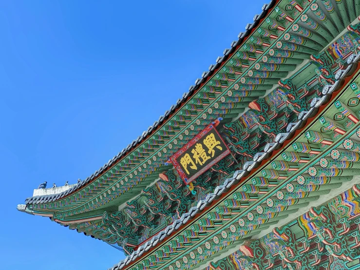 a large building with lots of colors on it's roof