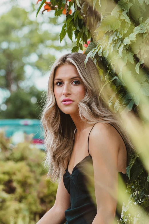 the model poses under a tree during a po shoot