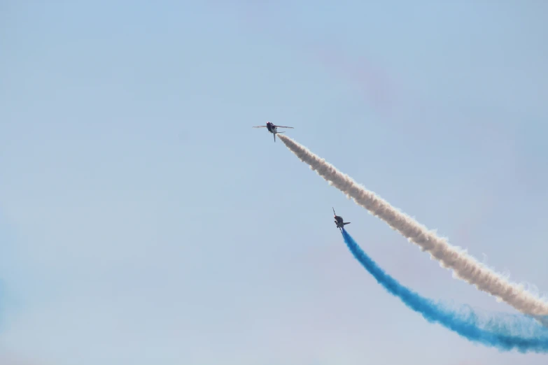 two air planes fly in opposite directions and the sky