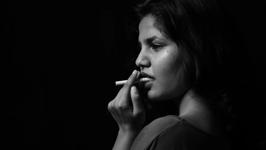 a woman smoking a cigarette and looking away