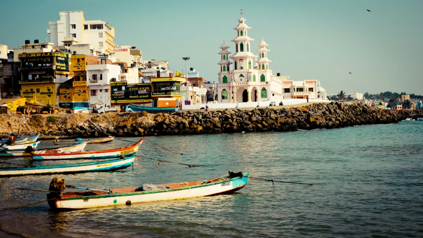 there are many small boats in the water next to a city