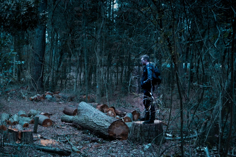 a man in a dark woods with trees on the side