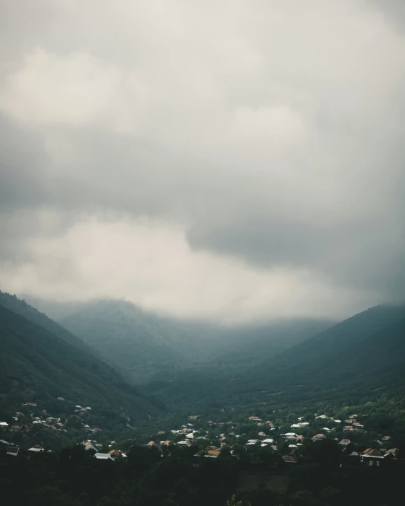 dark clouds hover over a city on a mountainous hillside