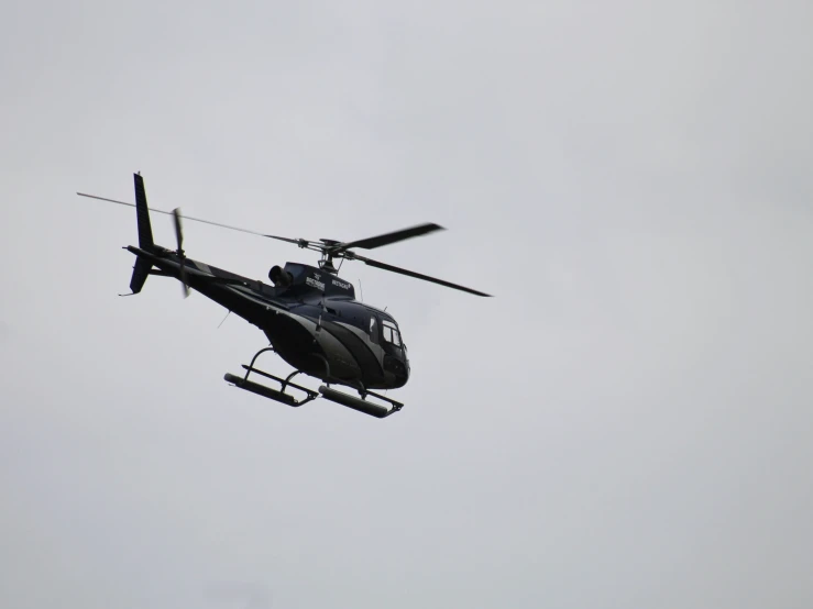 a large helicopter flying in a foggy gray sky